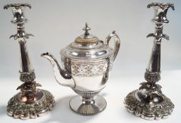 A pair of Sheffield plated candlesticks, with vine, foliage and scroll decoration, shaped bases,