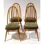 A set of four Ercol beech stick back kitchen chairs