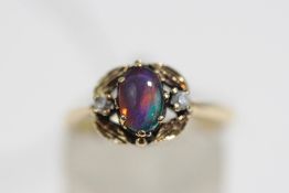 An opal triplet ring, stamped '9k', the cabochon between stone set shoulders, finger size M, 2.