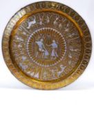 A brass wall plate decorated with copper and white metal with Egyptian figures and motifs,