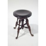 A late 19th century adjustable piano stool with turned legs and stretchers,