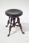 A late 19th century adjustable piano stool with turned legs and stretchers,
