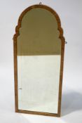 A walnut framed mirror with shaped arched top and bevelled plate, 130.