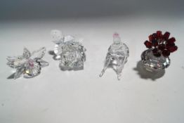 Four Swarovski Crystal ornaments: Seated ballerina, Rose, Orchid, Tulips in a vase,