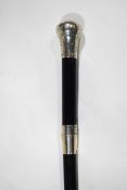 An ebonised walking cane with silver knob and bands,