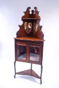 An Edwardian mahogany corner cabinet with raised mirrored back,