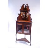 An Edwardian mahogany corner cabinet with raised mirrored back,