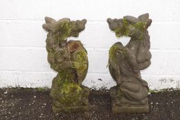 A pair of reconstituted stone gate post finials, in the form of heraldic mythical beasts,