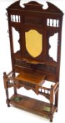 An Edwardian mahogany hall stand with four coat hooks flanking a shaped mirror plate above a drawer,