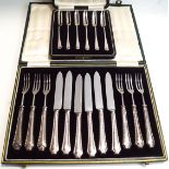 A set of six silver handled dessert knives and forks, with steel blades and tines,