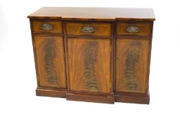 A Regency style mahogany sideboard, the rectangular breakfront top with crossbanding and stringing,