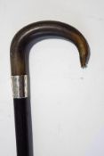 An ebonised walking stick with horn handle and silver band,