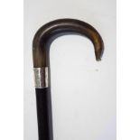 An ebonised walking stick with horn handle and silver band,