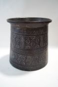 An unusual cylindrical copper pot with all over engraved decoration,