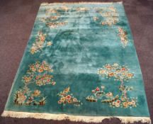 A large modern Chinese carpet with flowers and figures, on a duck egg blue ground,