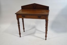 An Edwardian mahogany side table with raised back above one drawer on turned legs.