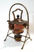 An Arts and Crafts style copper kettle on stand with wicker handle