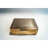 A silver cigarette box, with engine turned decoration and wood lined,