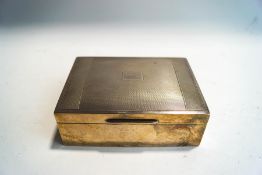 A silver cigarette box, with engine turned decoration and wood lined,
