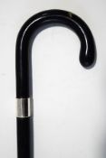 An ebonised walking stick with wide silver band