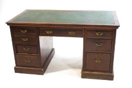 An Edwardian mahogany kneehole desk with leatherette inset top on plinth base,