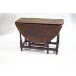 An 18th century oak drop leaf table with gateleg action,