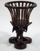 A 20th century mahogany jardiniere stand with slatted sides, upon a carved dolphin triform base,