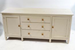 An oak and pine dresser base with three drawers and a cupboard door, with turned handles and legs,