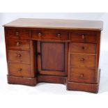 A Victorian mahogany pedestal desk with an arrangement of nine drawers around a cupboard door with