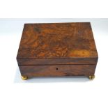 A Victorian walnut work box with compartmental interior, raised on ball feet,