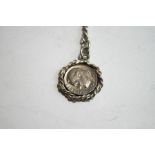 A silver watch chain, of graduated curb links, with a 1975 American One Dime coin attached,