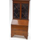 A 19th century mahogany bureau bookcase with two glazed doors above a fall front,