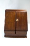 An early 20th century mahogany stationery cabinet, with hinged doors enclosing fitted racks,