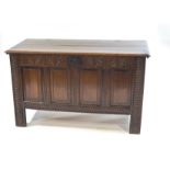 An 18th century oak coffer with carved and panel front and sides,