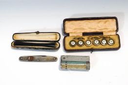 A set of six dress buttons; a cased cigarette holder; a lighter;