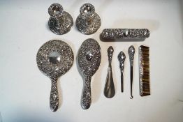 A silver dressing table set, comprising a pair of candlesticks, a hair brush, a clothes brush,