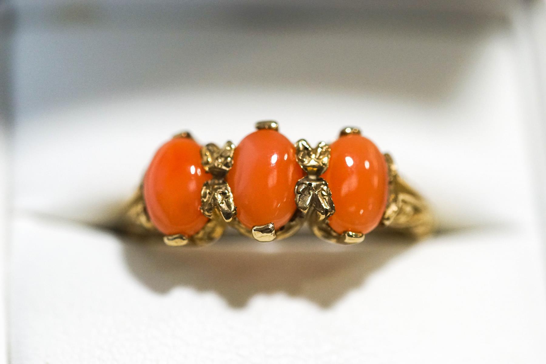 A 9 carat gold three stone coral ring, finger size O1/2, 3.