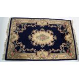 A large modern Chinese rug with central medallion on a dark blue field,