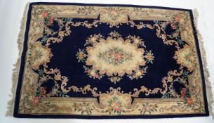 A large modern Chinese rug with central medallion on a dark blue field,