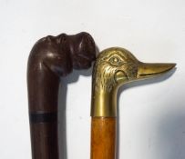 A carved hardwood walking stick, modelled with a hippo's head, and a further walking stick,