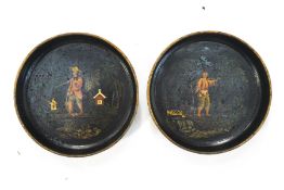 A pair of 18th century tole coasters, each decorated with chinoisere figures on a black ground,