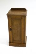 A Victorian oak pot cupboard with raised back and panelled door,
