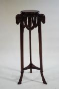 A carved mahogany jardiniere stand with rams heads supports,