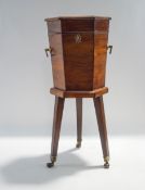 A George III style mahogany hexagonal wine cooler, on tripod base with brass castors,