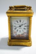 A miniature brass cased carriage clock with engraved decoration and enamel panels,