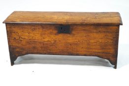 An 18th century elm six plank coffer, with chip carved decoration to the edges, interior candle box,