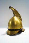A brass fireman's helmet with replacement strap,