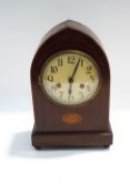 An Edwardian mahogany eight day mantel clock of lancet shape with inlaid paterae, with pendulum,