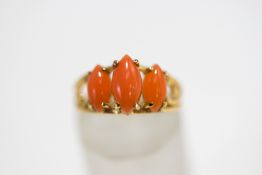 A three stone coral ring, stamped '14K', finger size M, 2.