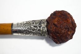A Malacca walking cane with carved dragon knop and white metal collar